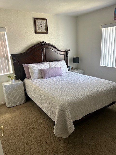 A bed with a white comforter and a wooden headboard.
