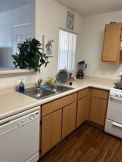 A kitchen with wooden cabinets and a white dishwasher.