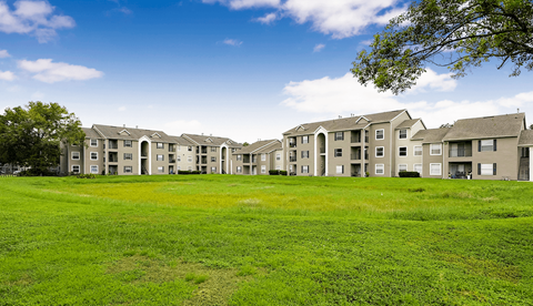 A row of houses with green lawns in front.