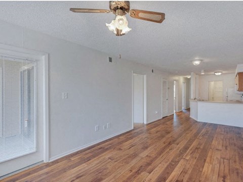 a living room with a wood floor and a ceiling fan