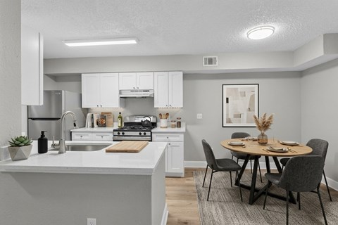 A modern kitchen with a dining table set for four.