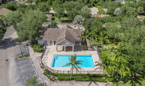 A house with a pool surrounded by trees.