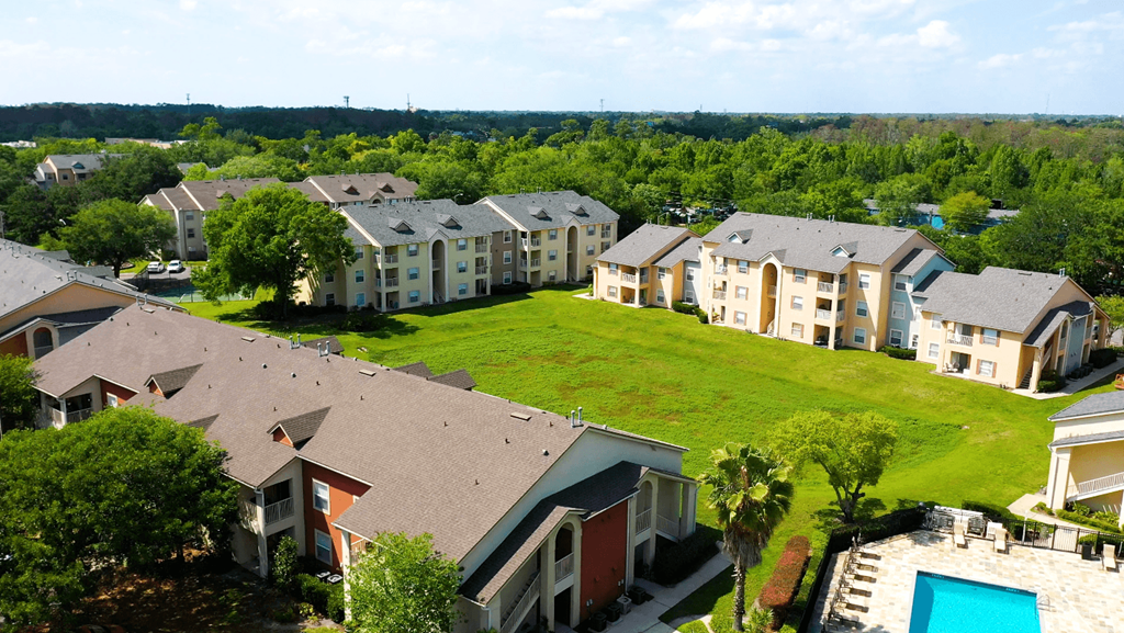 A bird's eye view of a residential area with houses and a swimming pool.