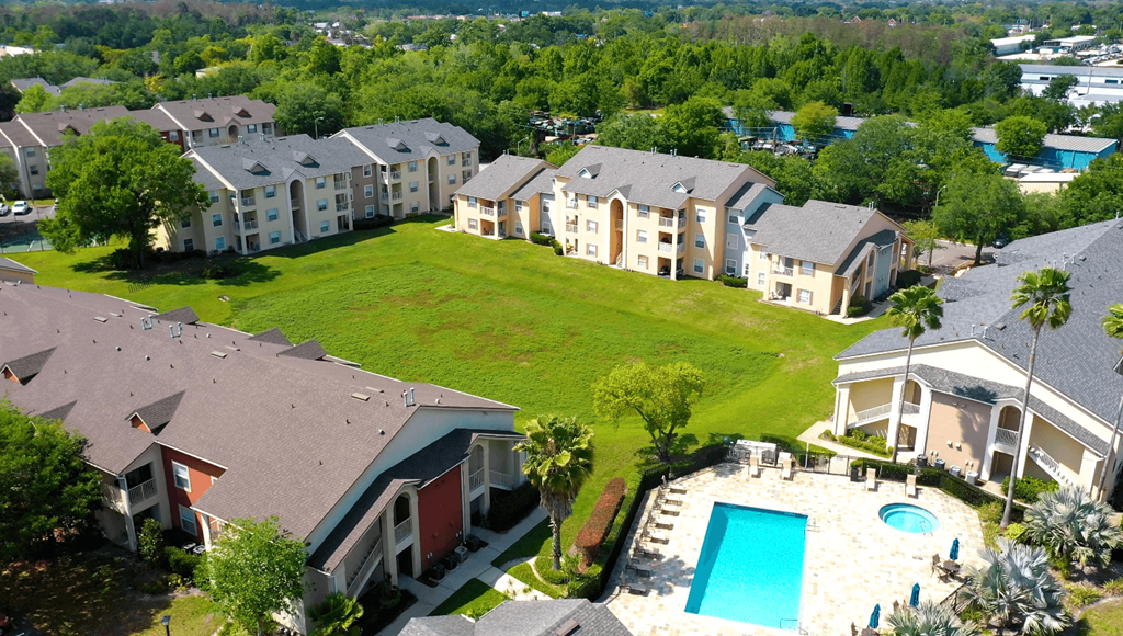 A bird's eye view of a residential area with houses and a swimming pool.