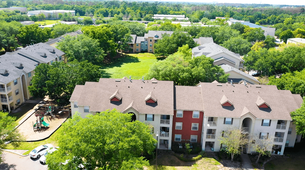 A bird's eye view of apartment buildings surrounded by trees.
