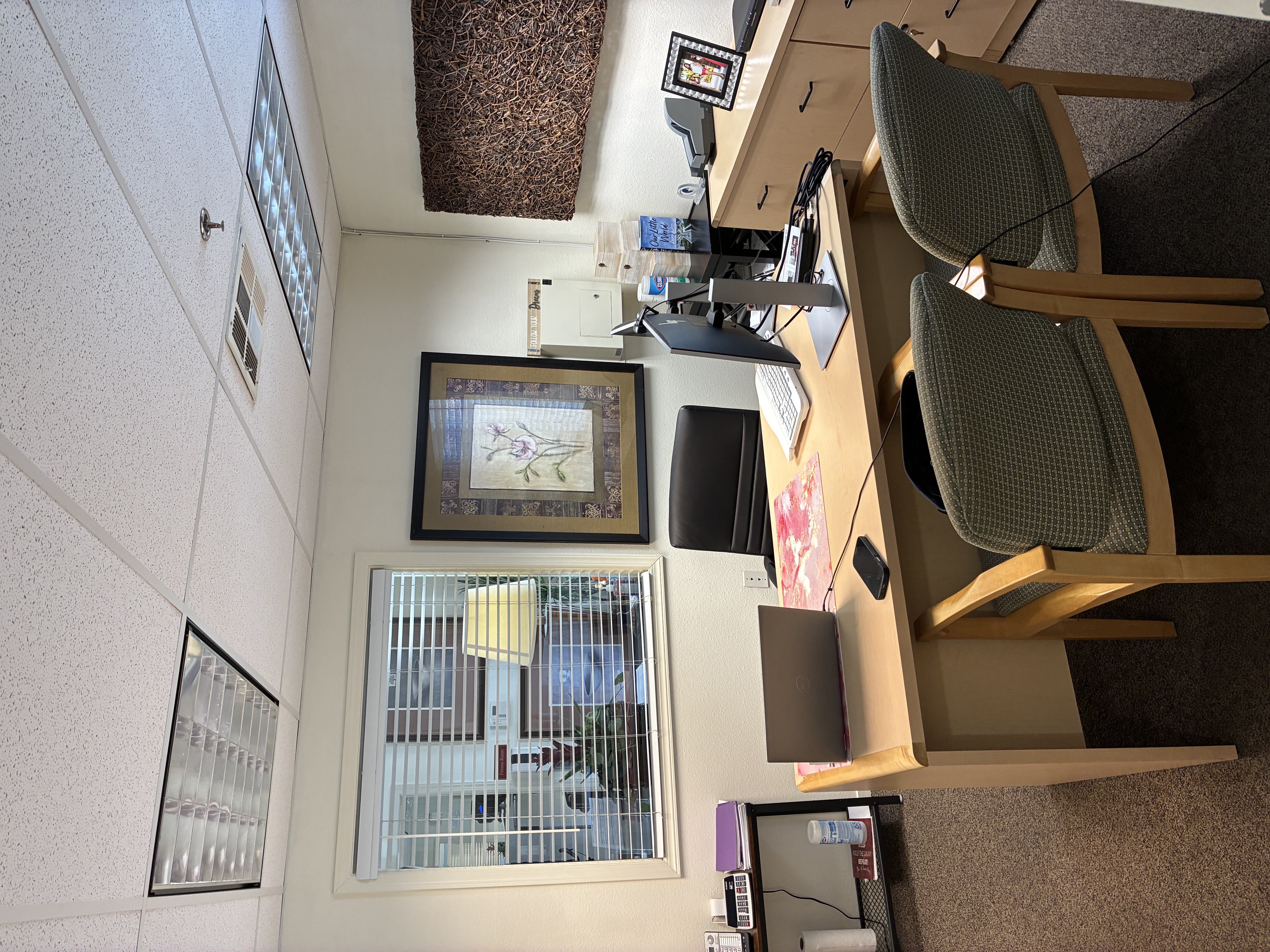 A room with a desk, chair, and computer.