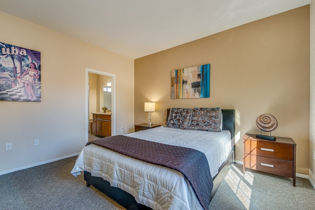 a bedroom with a bed and a dresser and a mirror