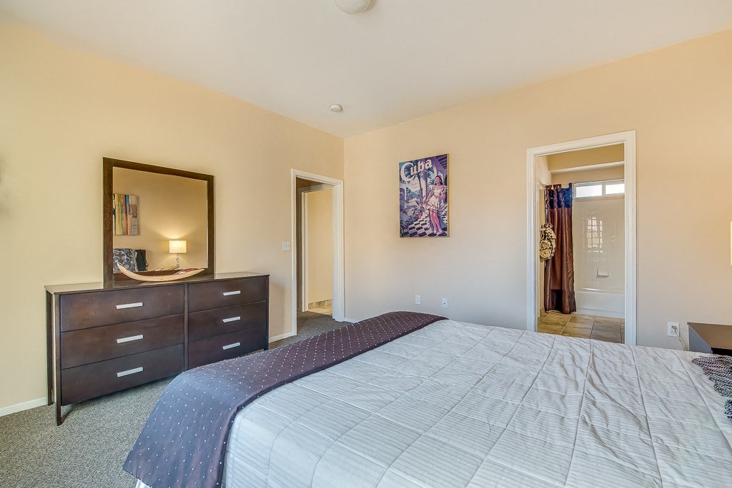 a bedroom with a bed and a dresser and a mirror