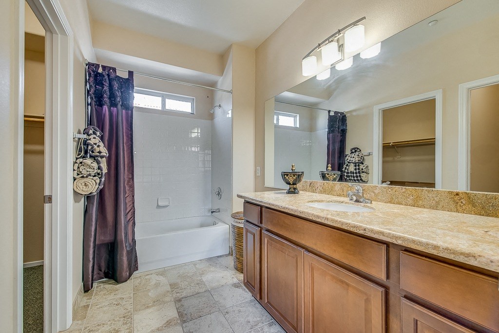 a bathroom with a shower and a sink and a mirror