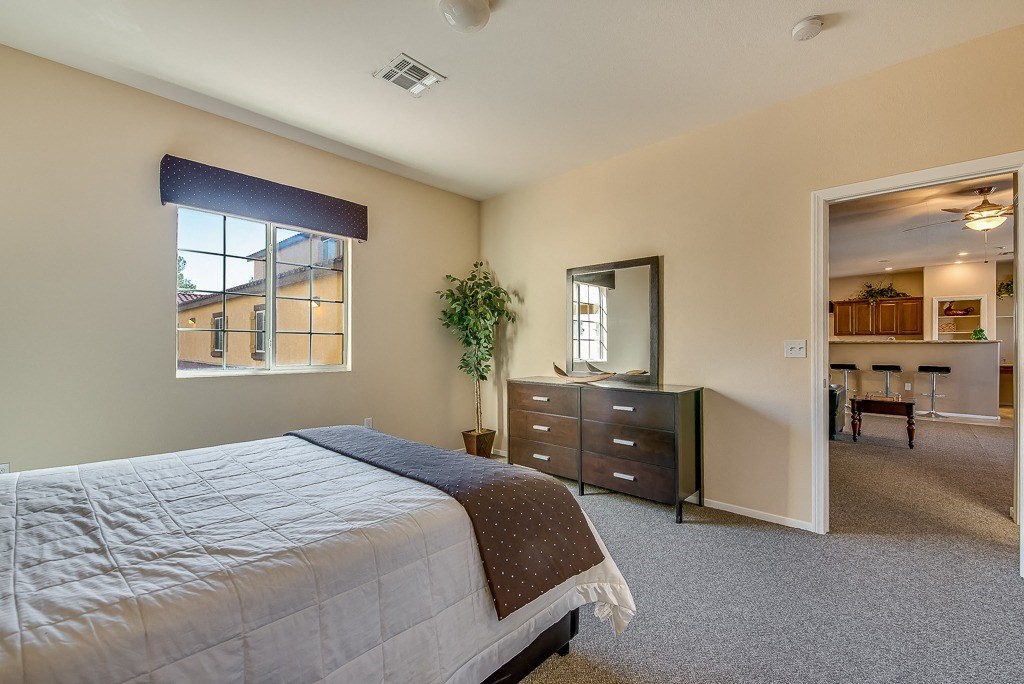 a bedroom with a bed and a dresser and a window
