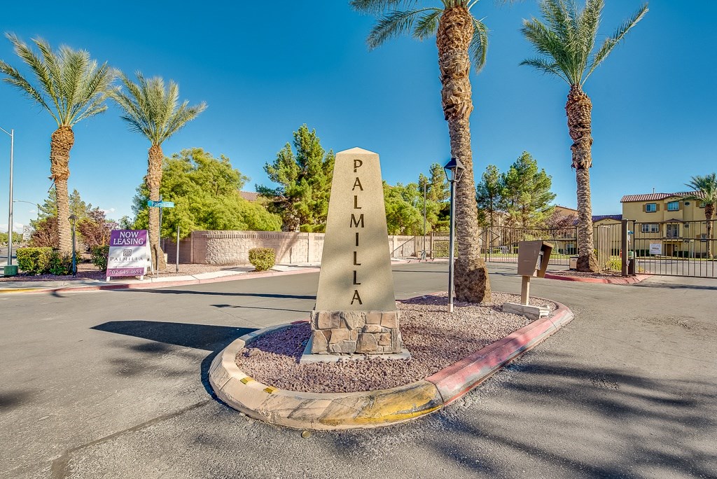 a monument in the middle of a street with palm trees