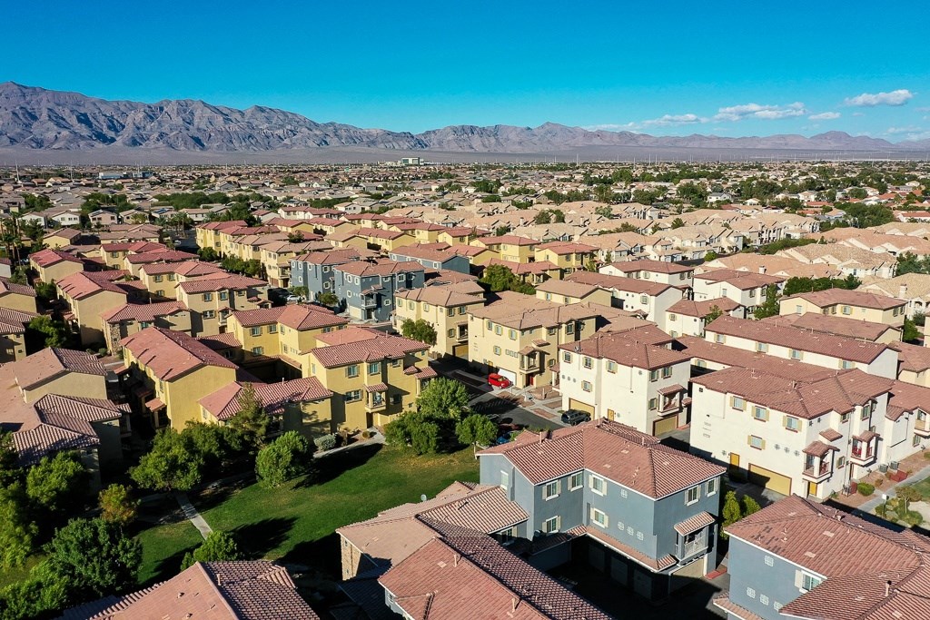 an aerial view of a neighborhood of houses with mountains in the background