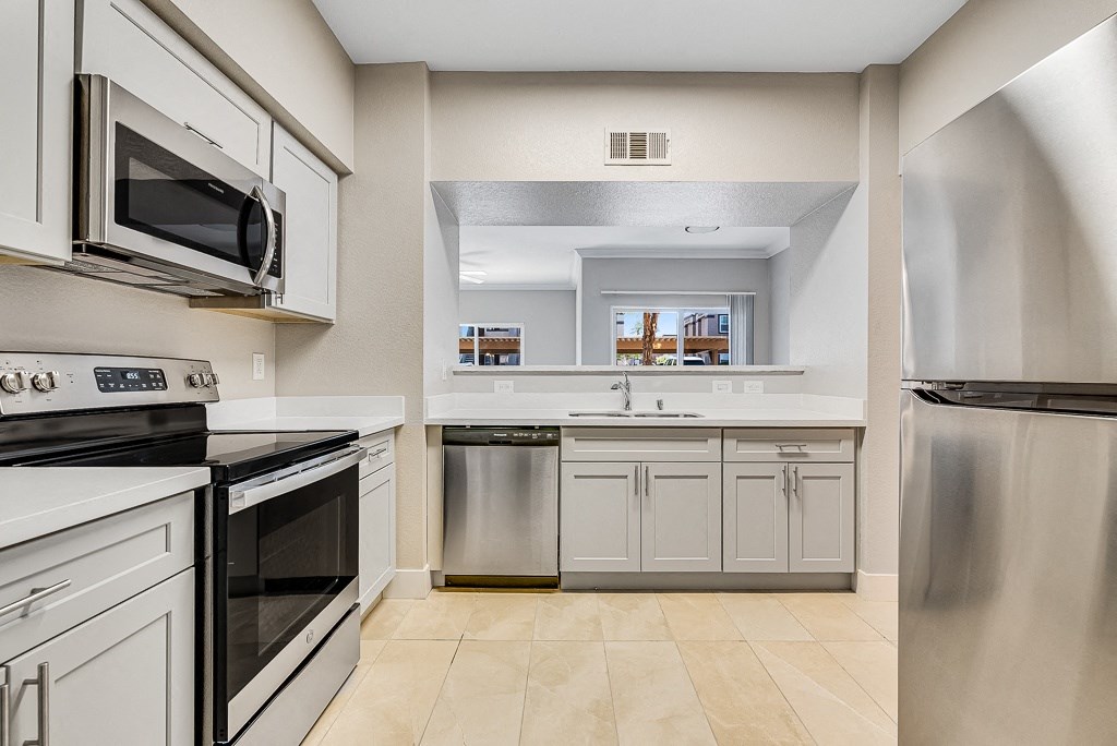a kitchen with stainless steel appliances and white cabinets