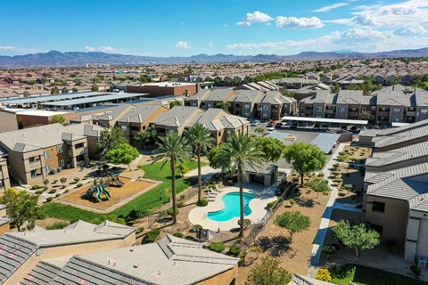 an aerial view of a neighborhood with a swimming pool and palm trees