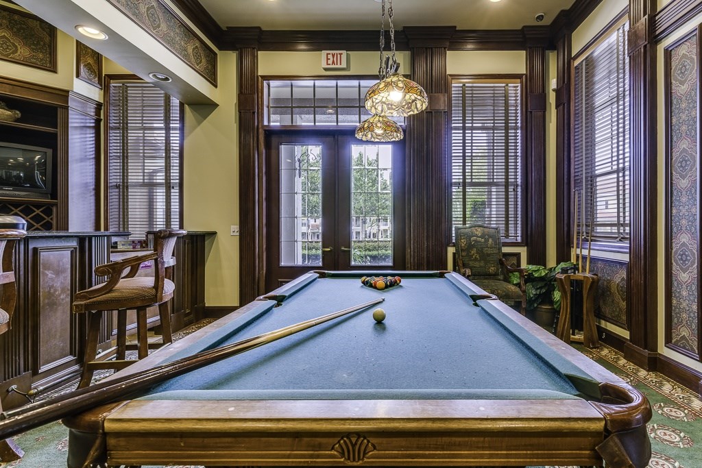 A pool table in a room with a view of the outside.