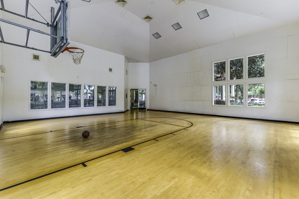 A basketball court with a ball on the floor and a basketball hoop on the ceiling.