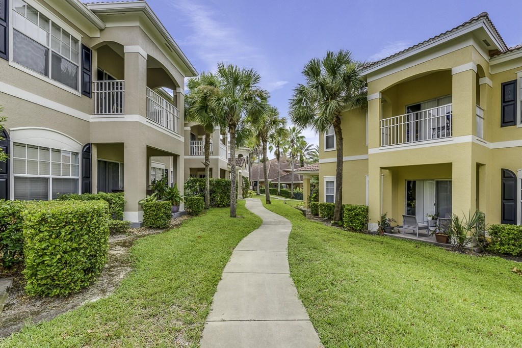 A row of apartment buildings with a walkway between them.