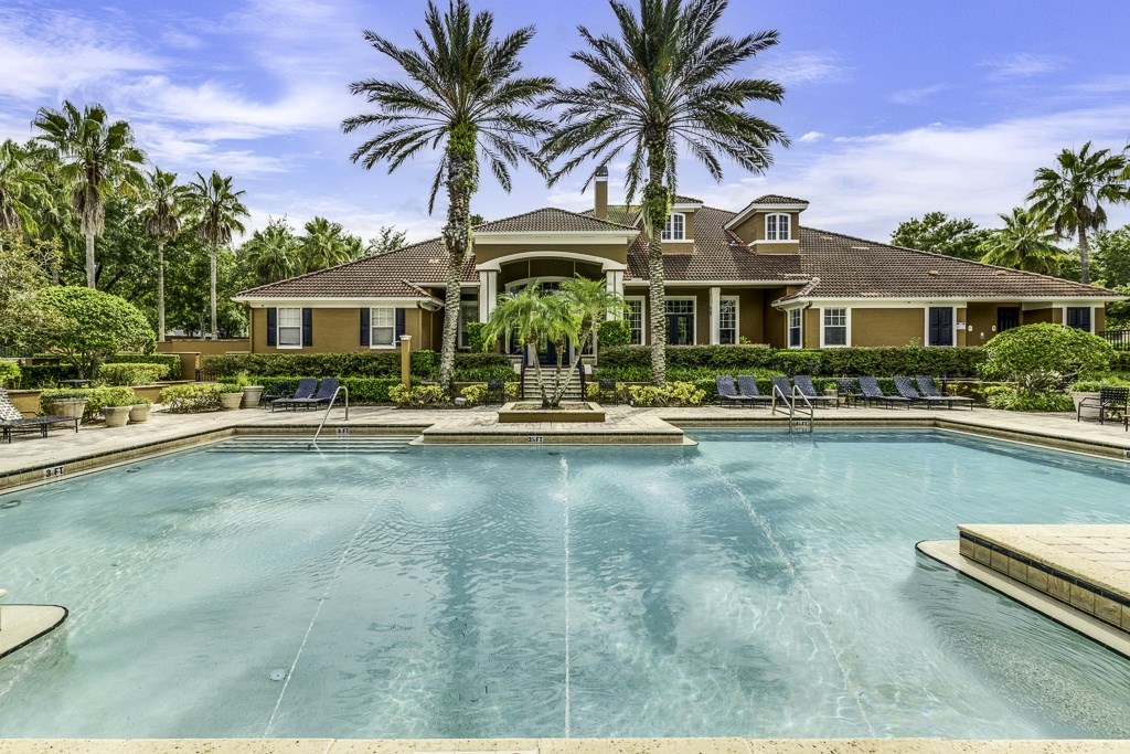 A large house with a pool in front of it.