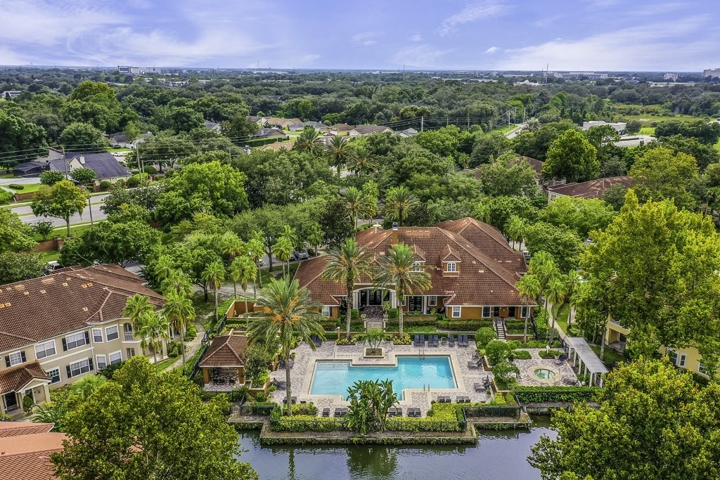 A large house with a pool surrounded by trees.