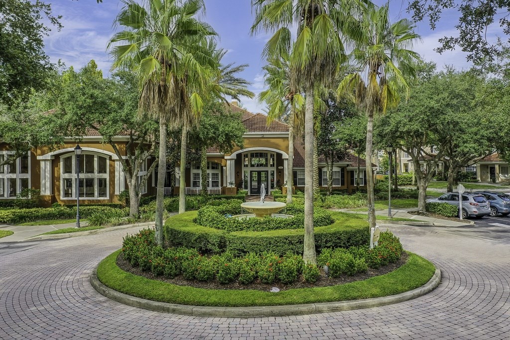 A building with a landscaped front yard and palm trees.