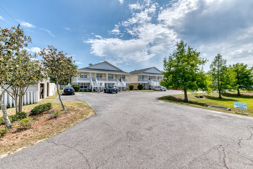 A large white building with a driveway in front of it.