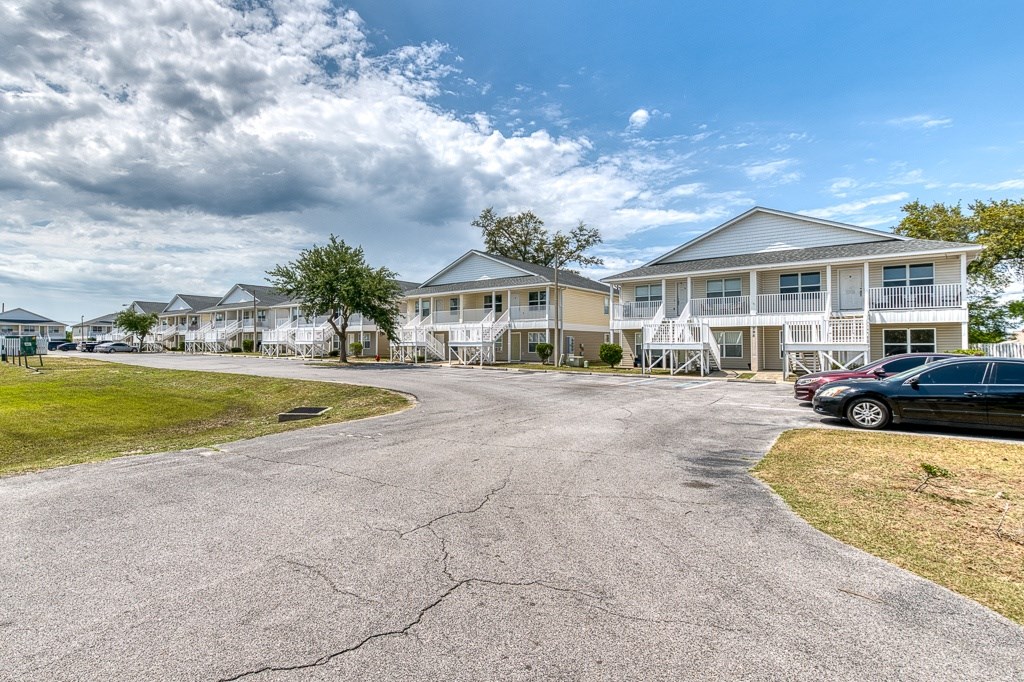 A large, multi-story building with a parking lot in front.