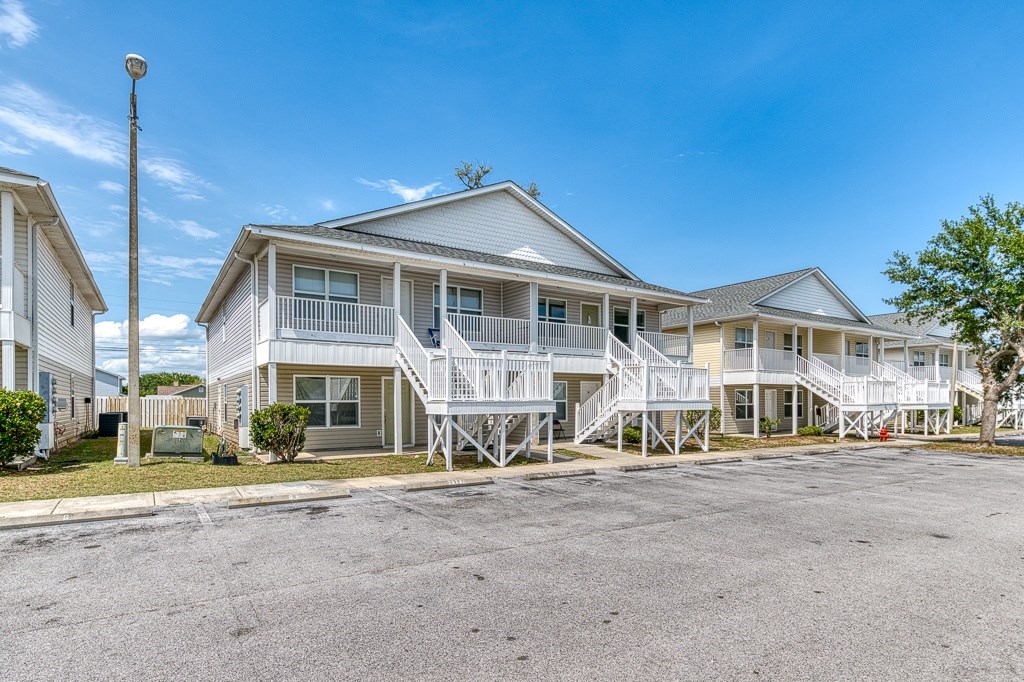 A row of houses with white balconies and a clear blue sky.
