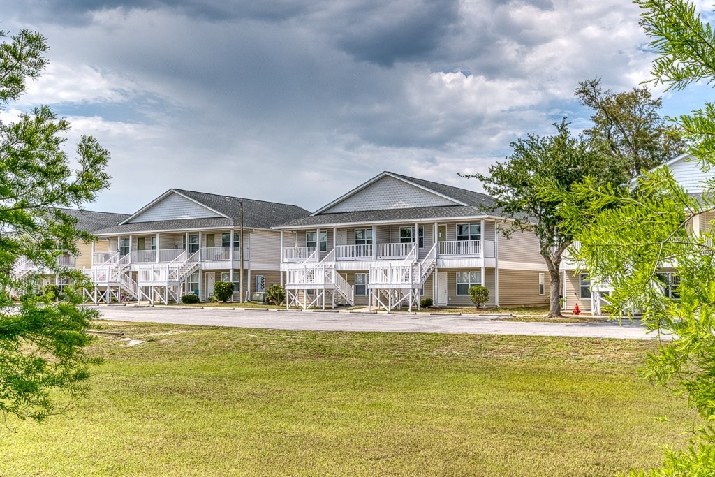 A large building with a grey roof and white railings.
