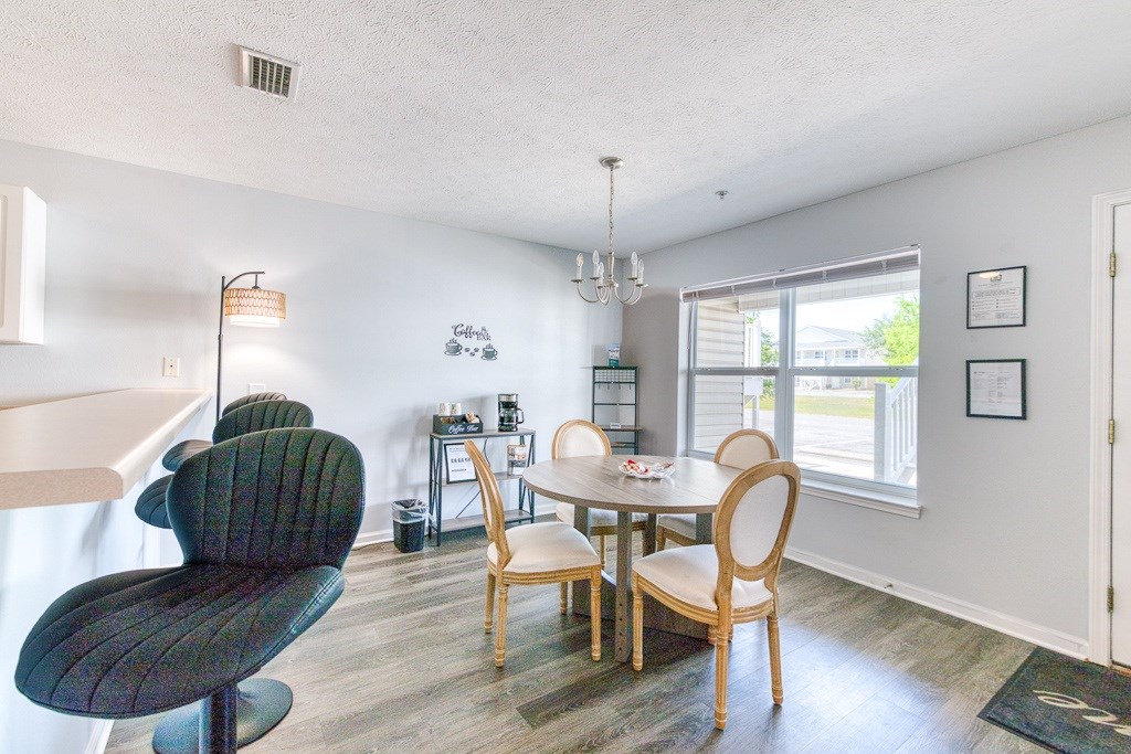 A dining room with a table and chairs.