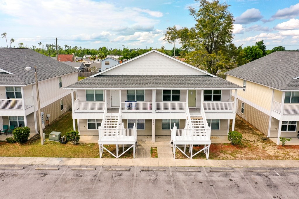 A row of houses with white balconies and a sign on the front porch.