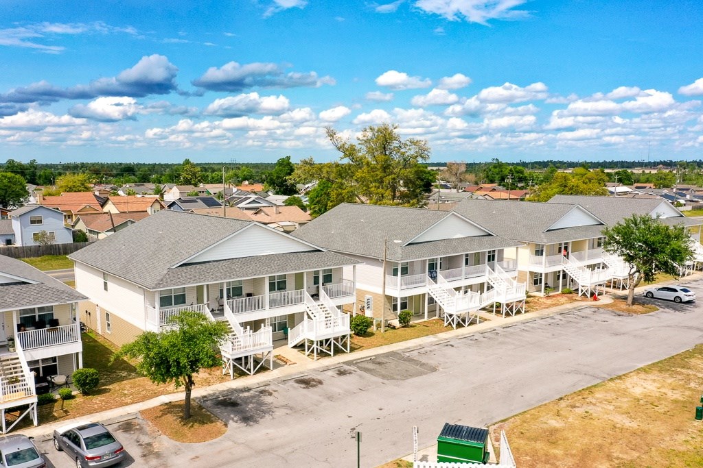 A sunny day at a residential complex with multiple houses and cars.