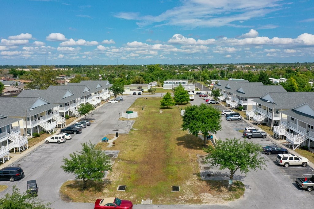 A parking lot with cars and a grassy area in the middle.