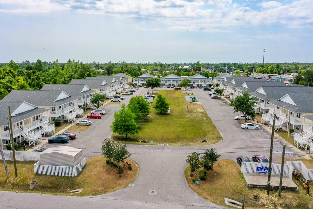 A bird's eye view of a residential area with houses and cars.