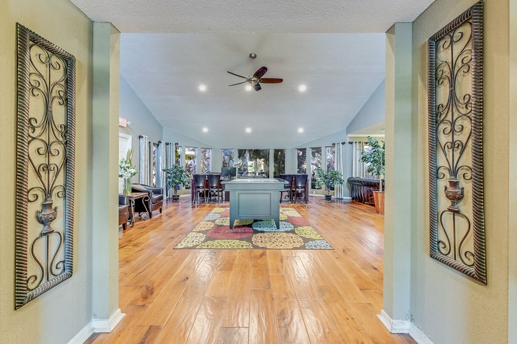 a large living room with a table and a ceiling fan