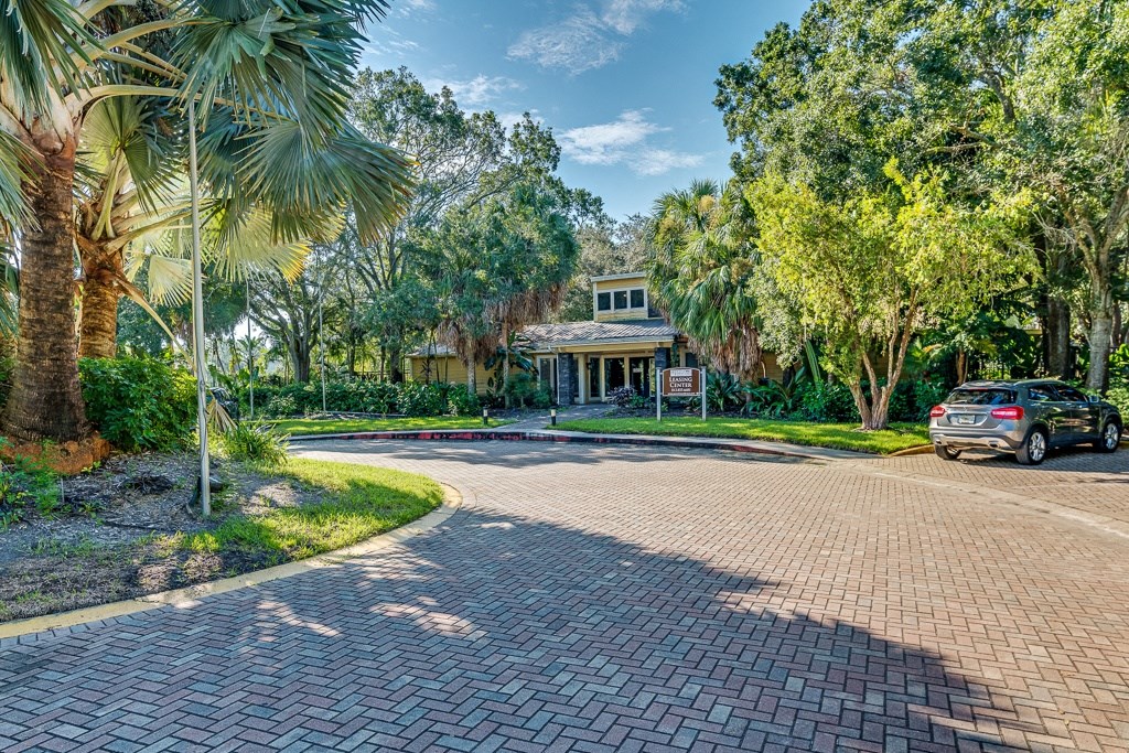 apartment complex with a driveway and a car parked in front of it