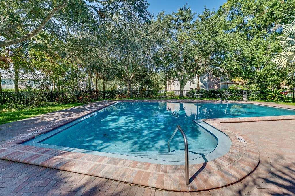 a swimming pool with trees in the background