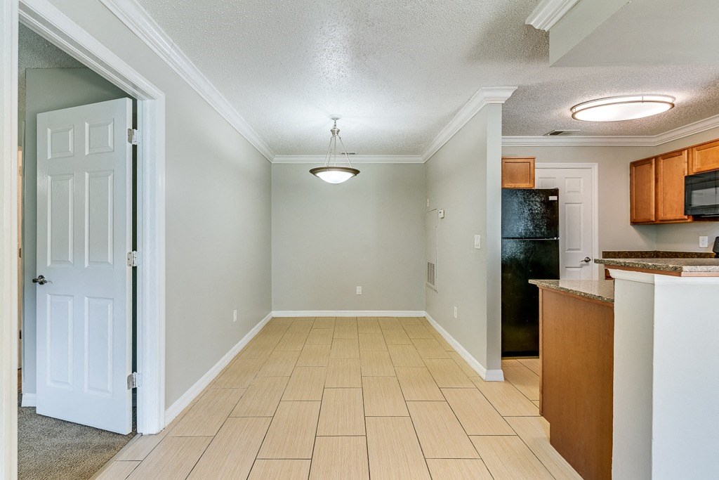 an empty kitchen and hallway with a door open to the living room