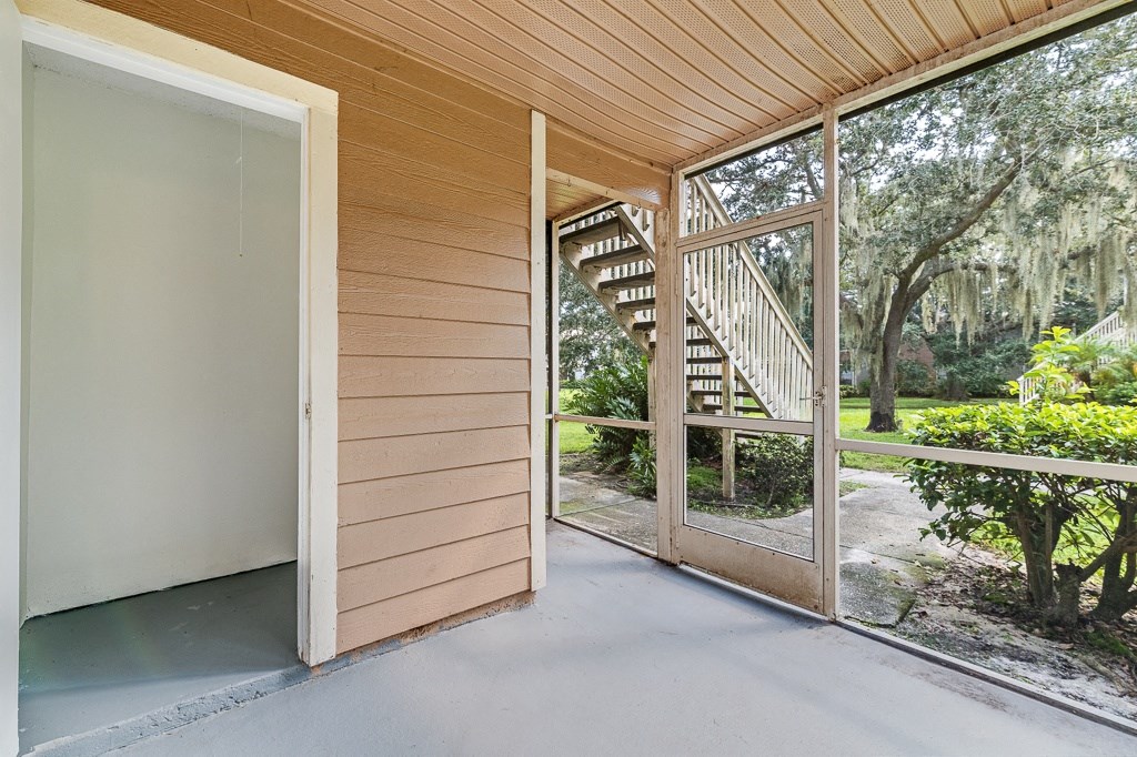 a sliding glass door opens to a porch with a view of a staircase