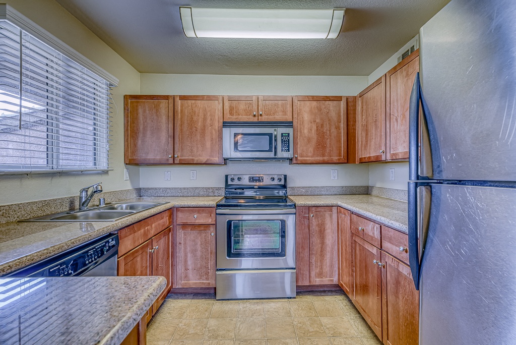 a kitchen with wooden cabinets and stainless steel appliances