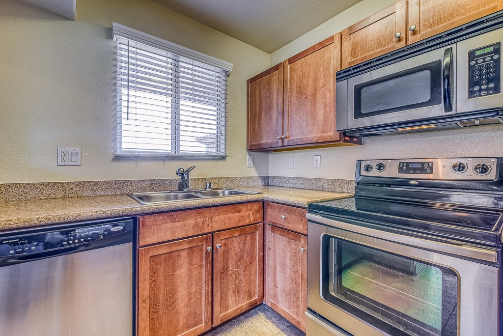 a kitchen with stainless steel appliances and wooden cabinets