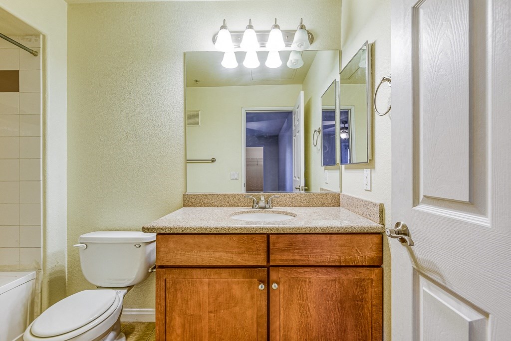 a bathroom with a sink toilet and a mirror