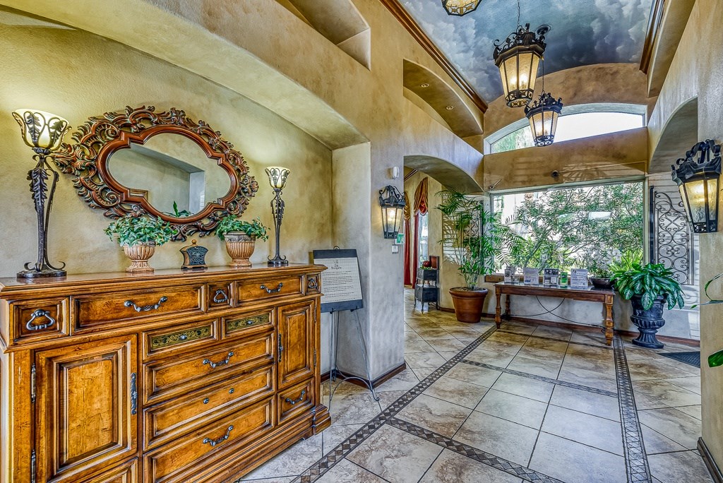 the entryway of a house with a dresser and a large window
