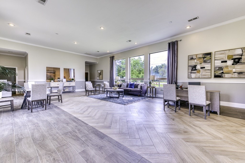 A spacious living room with a grey floor and white walls.