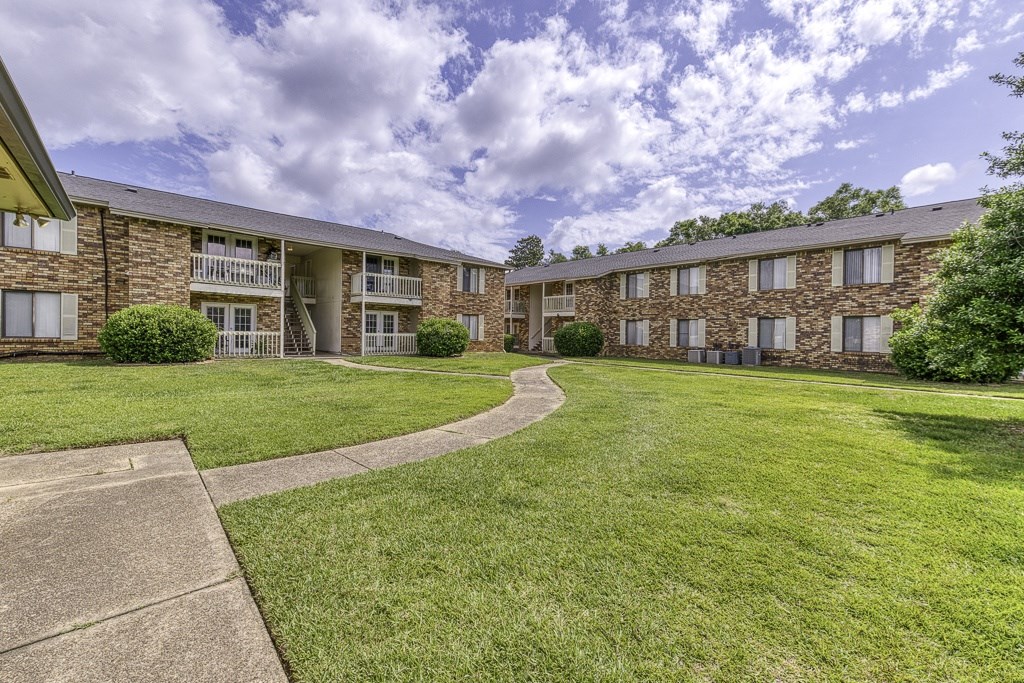 A grassy area in front of a building with a walkway.