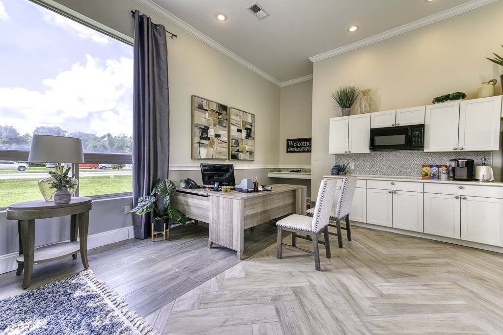 A modern kitchen with a desk and chair in the middle of the room.