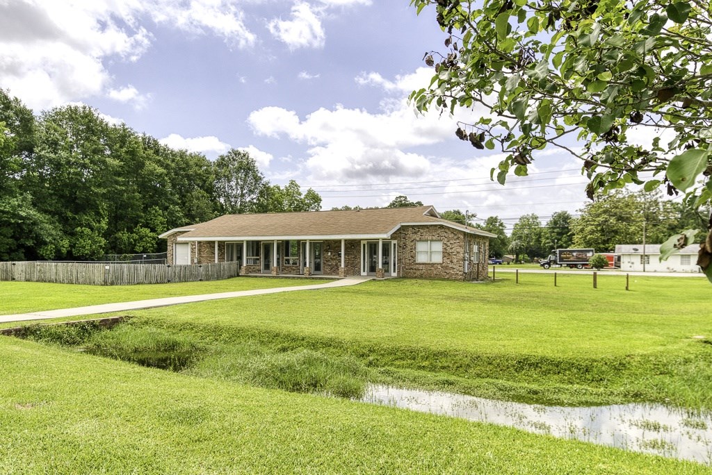 A house with a fence and a green lawn in front.