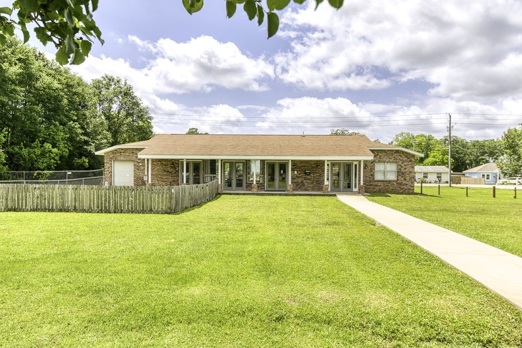 A house with a green lawn in front of it.