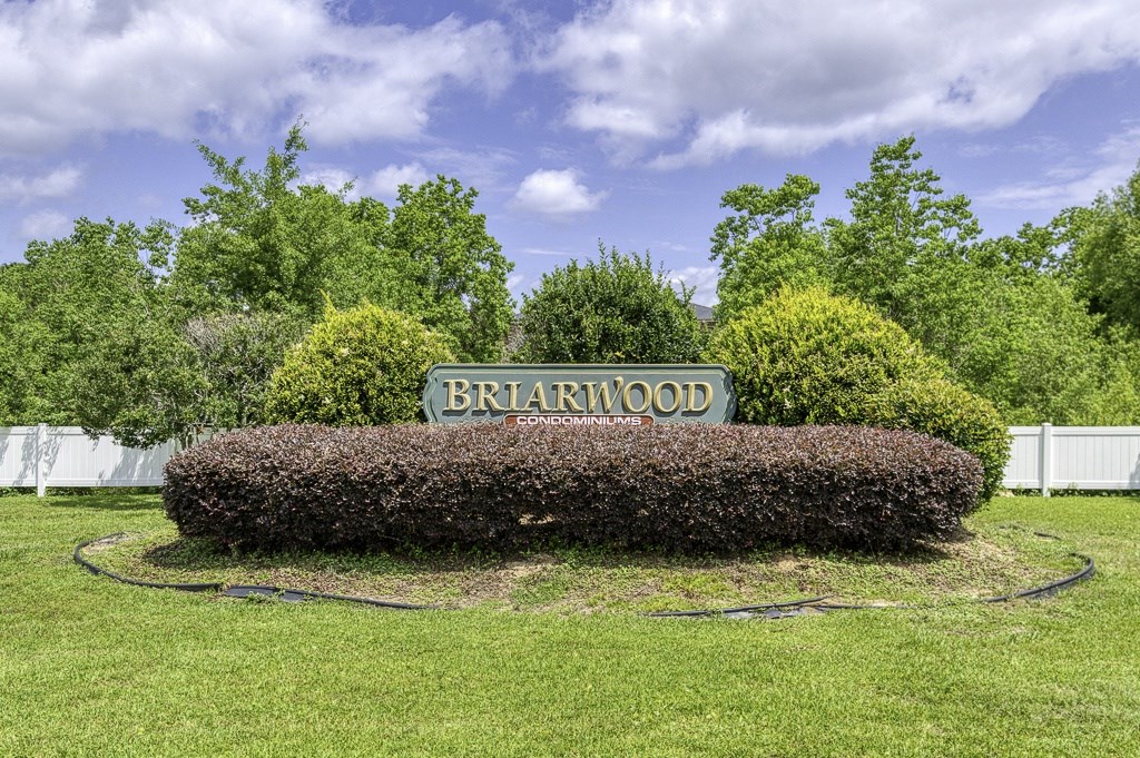 A sign that says "Briarwood" is surrounded by a hedge.