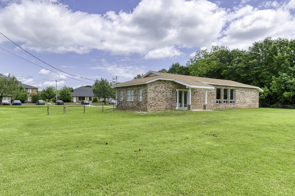 A house with a green lawn in front of it.