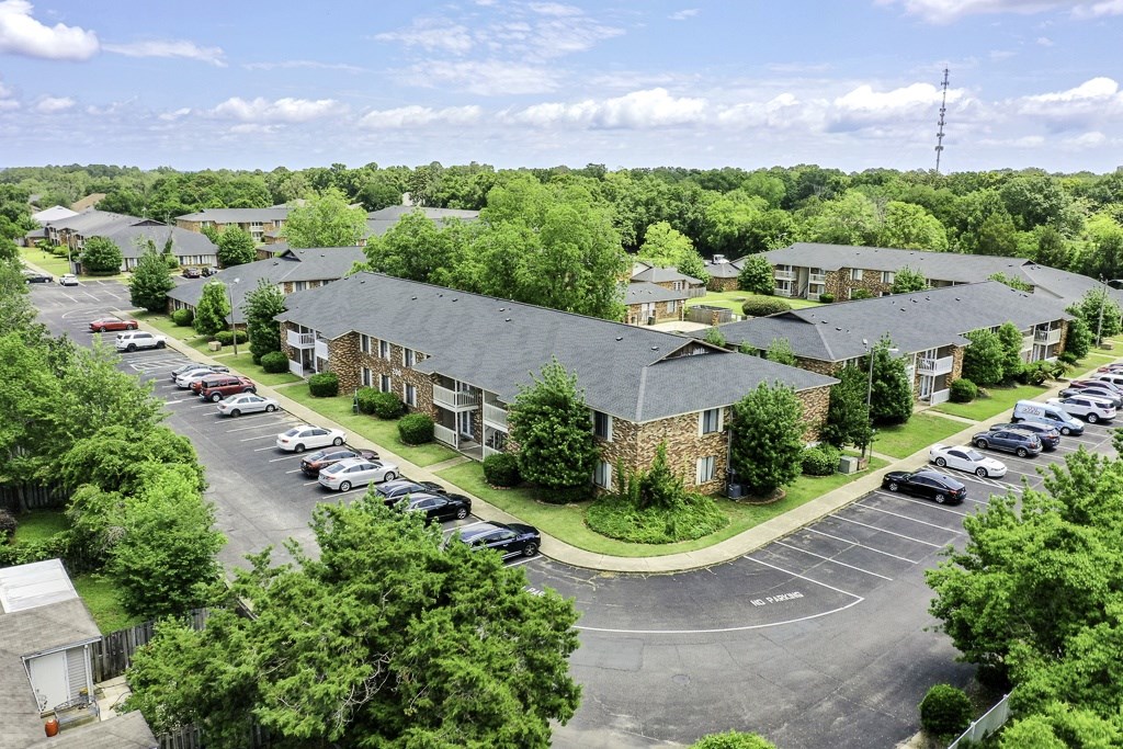 A parking lot is surrounded by apartment buildings.